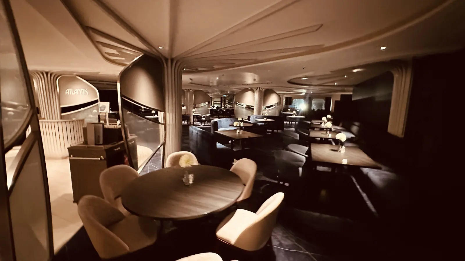 Elegante Eventlocation mit gedeckten Dinner-Tischen in stimmungsvoller Lounge-Atmosphäre