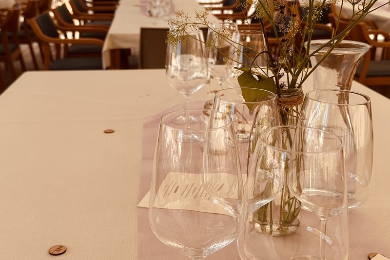Festlich gedeckte Hochzeitstafel im Festzelt mit Wildblumen und Lampions